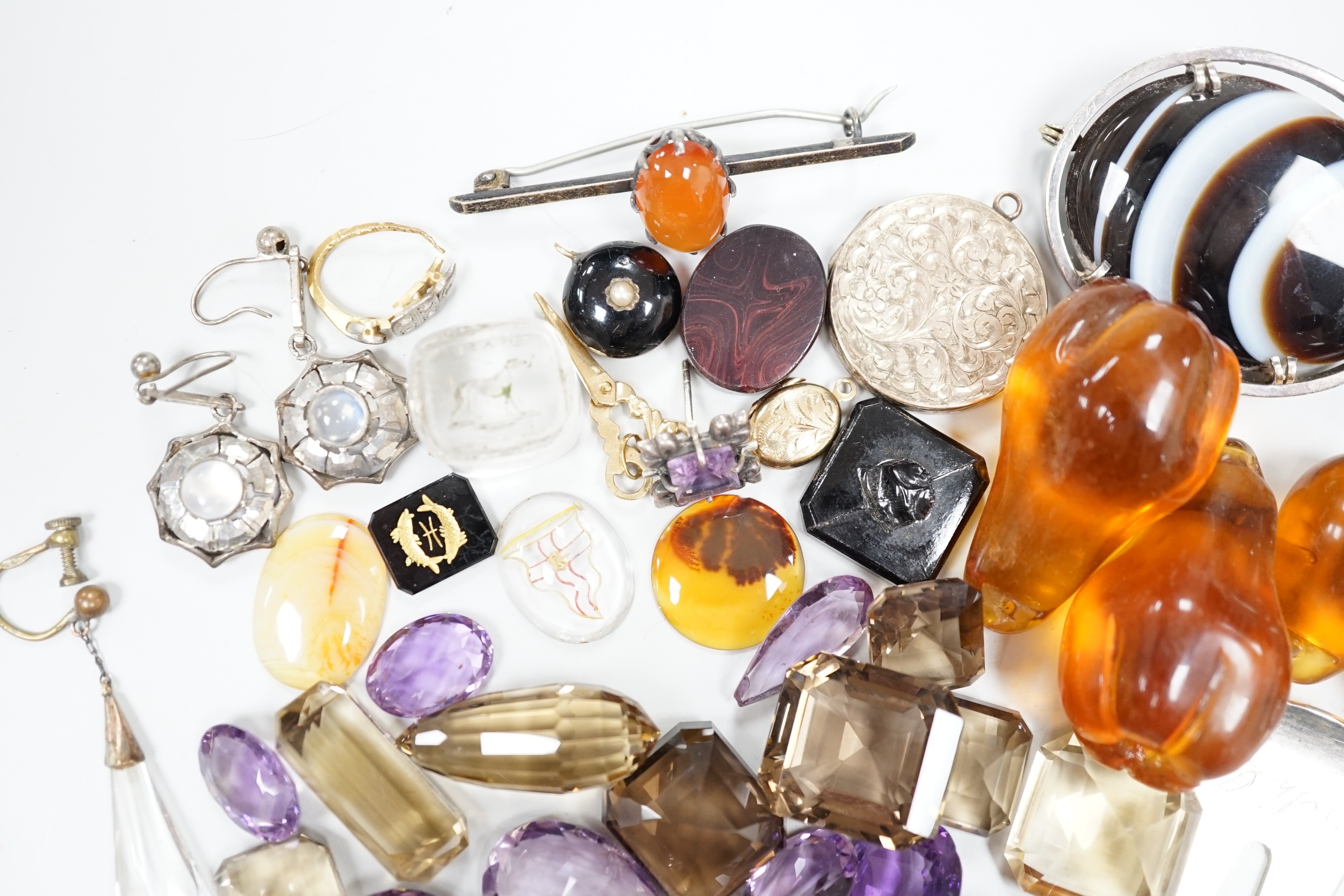 Assorted jewellery etc. including unmounted seals, agate brooch, engraved yellow metal locket and a quantity of unmounted cut amethysts and citrines.
